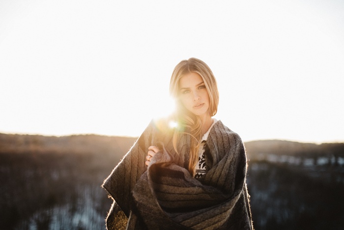 Woman wrapped in a blanket in sunlight