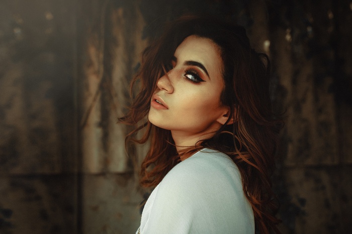 Woman with dark wavy hair and makeup