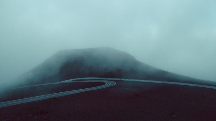 Misty mountain road winding through fog
