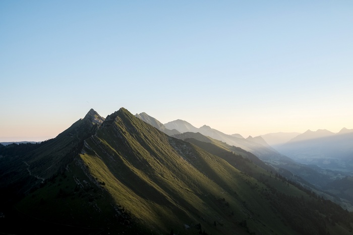 Mountain range with sunbeams at sunrise