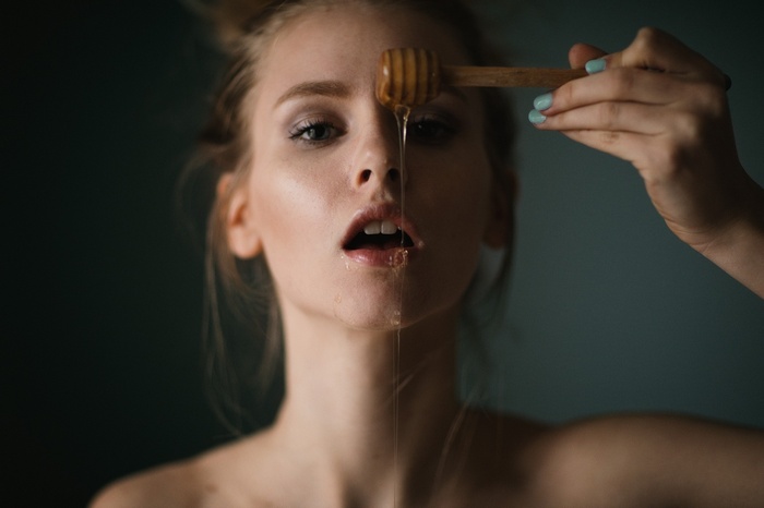 Woman with honey dipper and dripping honey