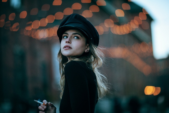 Woman in a hat smoking outdoors