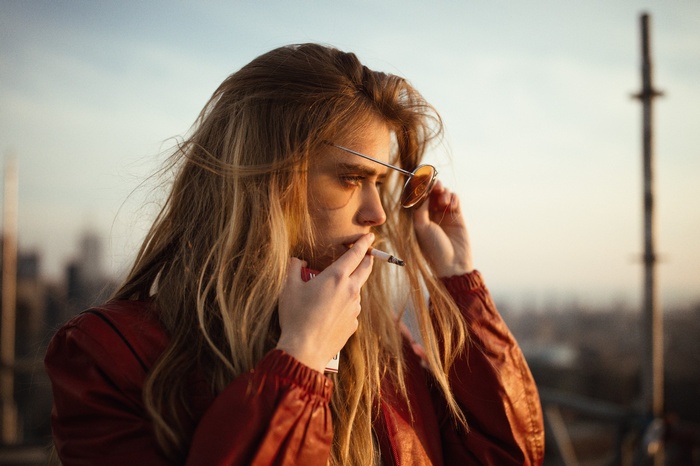 Woman in orange jacket smoking Marlboro cigarettes