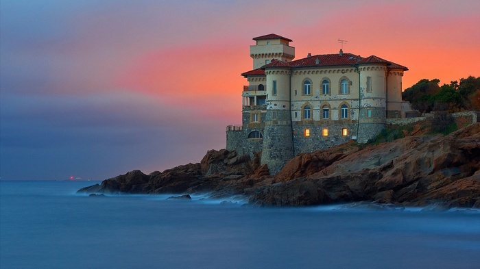 Castello del Boccale at sunset with waves crashing on rocks