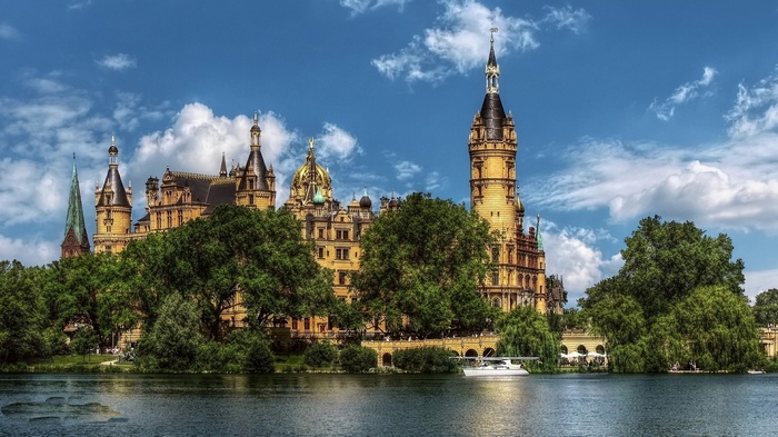 Schwerin Palace on a lake with trees and clouds