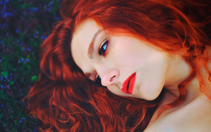 Redhead woman with bright red lips and blue eyes