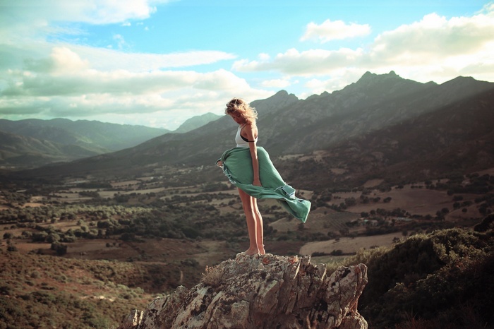 Woman with a green towel on a rocky mountain