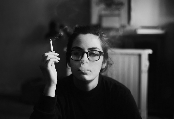 Woman with glasses smoking a cigarette in monochrome