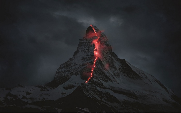The Matterhorn mountain illuminated by red lights at night