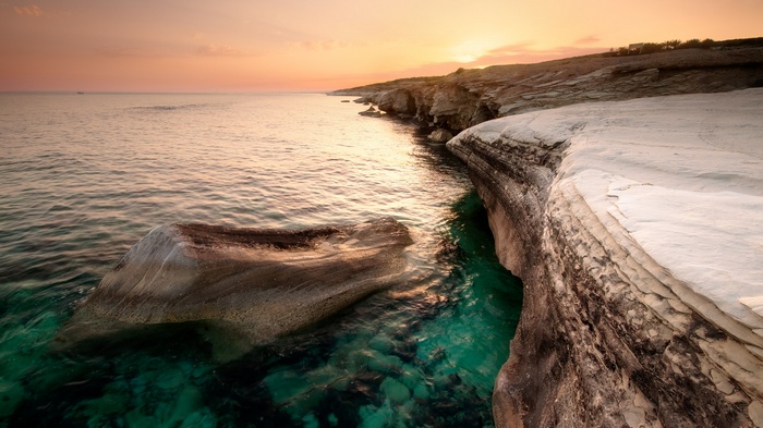 Coastal cliffs at sunset with turquoise water