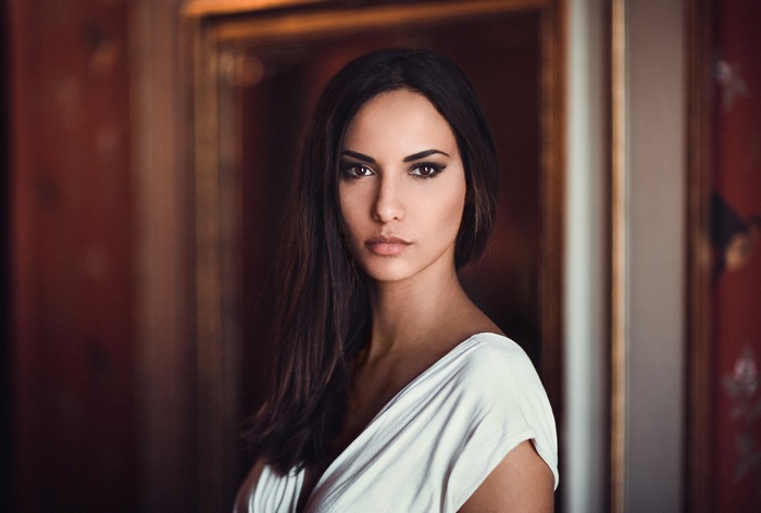 Woman with dark hair in a white dress