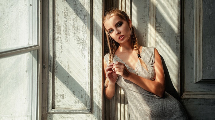 Woman with braids leaning against a door