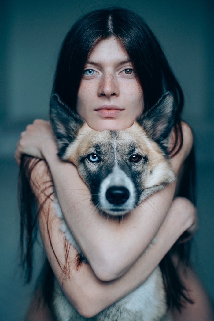 Woman with heterochromia hugging a dog