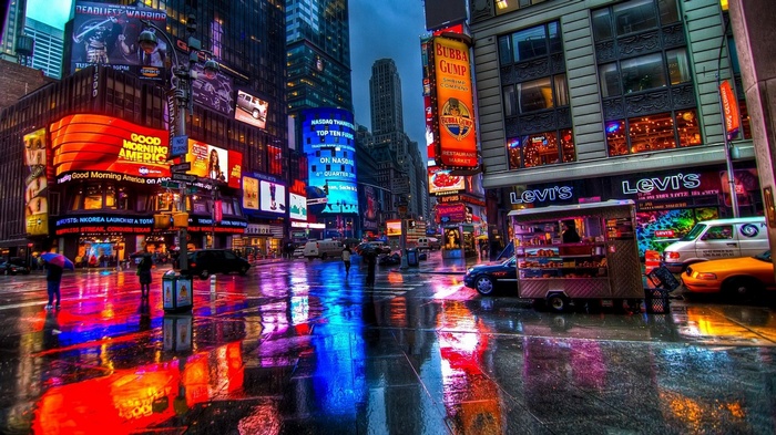 Times Square at night with colorful lights and rain