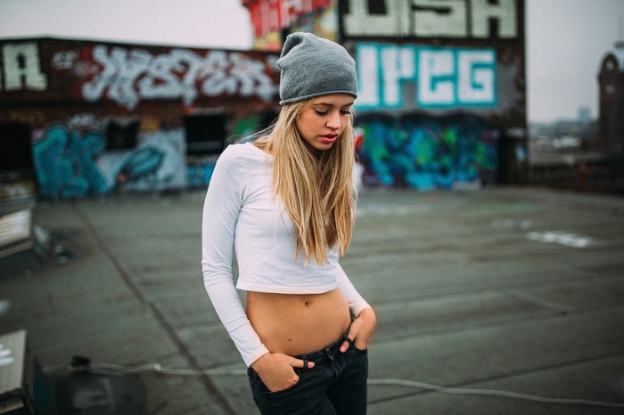 Woman in beanie and crop top on rooftop