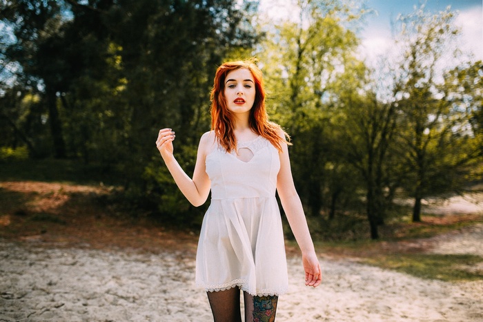 Redhead woman in white dress with tattoo