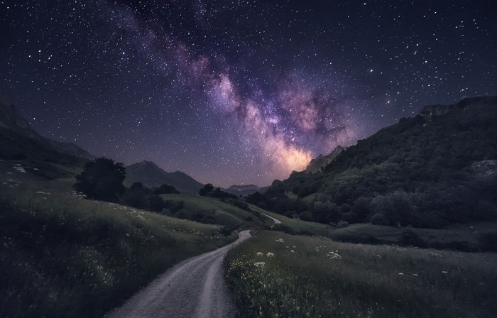 Milky Way over a mountain valley with a dirt road