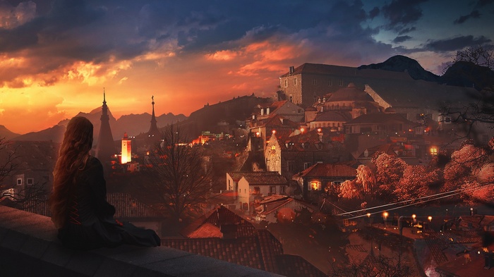 Woman overlooking a city at sunset