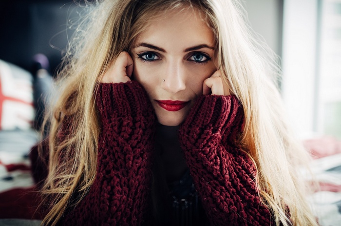 Woman with blonde hair and blue eyes wearing a sweater