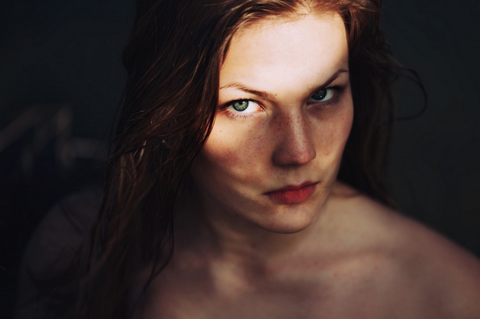 Woman with wet hair and freckles looking at viewer