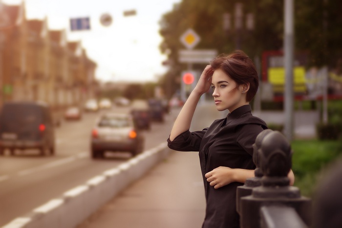 Woman with short hair in a black shirt looking away