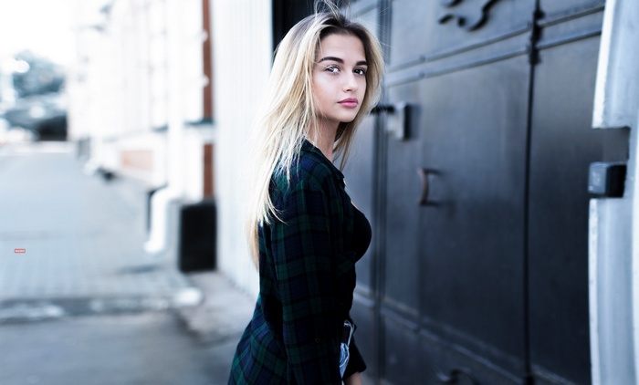 Woman with blonde hair wearing a plaid shirt