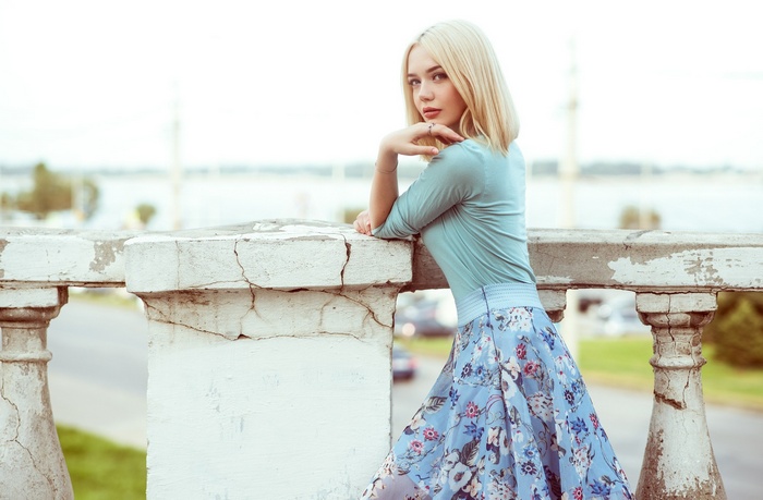 Woman with blonde hair leaning on a railing
