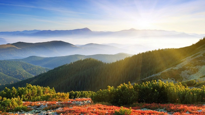 Misty mountains and sunlit hills landscape