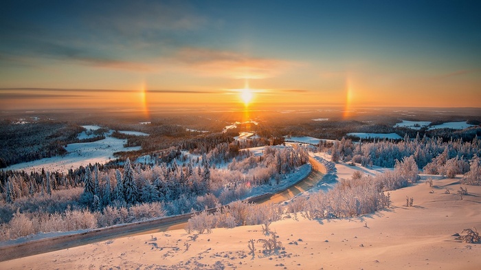 Winter landscape with sun rays at sunset