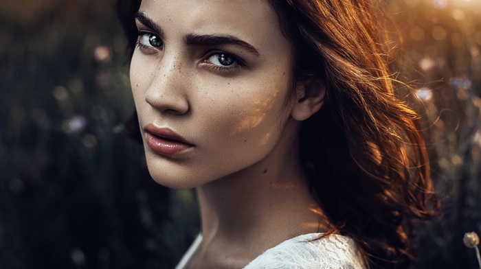 Portrait of a woman with freckles in a field