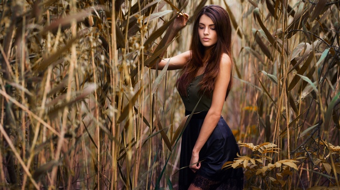 Woman in a skirt standing in tall grass