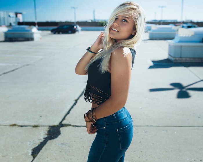 Woman in jeans and black top smiling