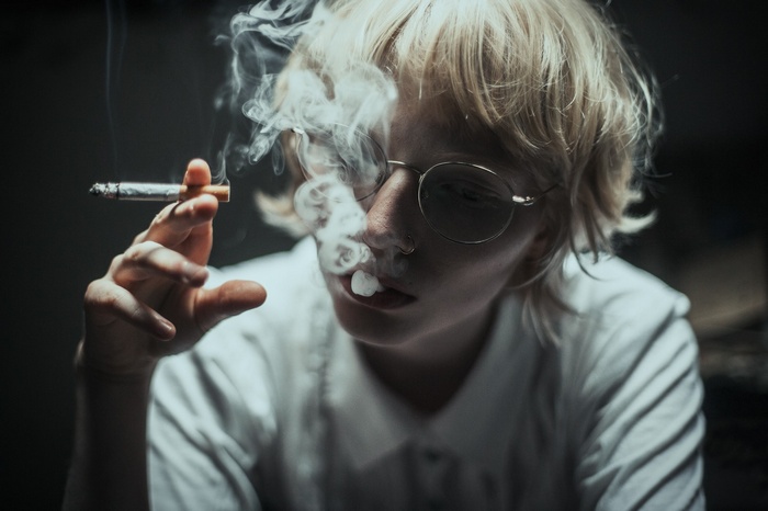 Woman with blonde hair smoking a cigarette