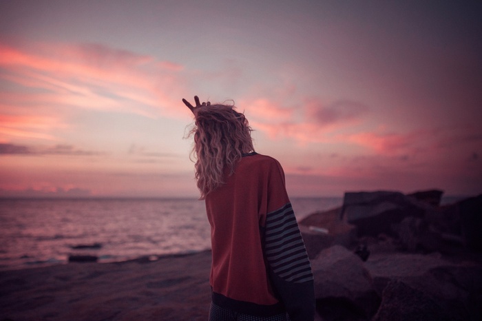 Woman with blonde hair on a beach at sunset