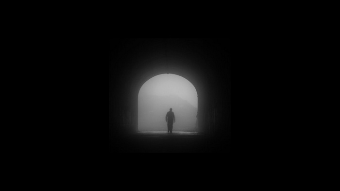 Man walking through a misty tunnel
