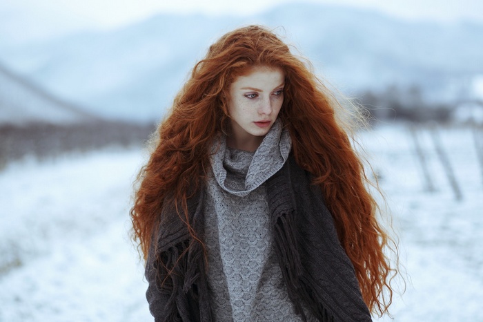 Redhead woman with long wavy hair in winter
