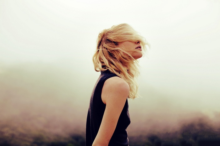 Woman with blonde hair covering her face
