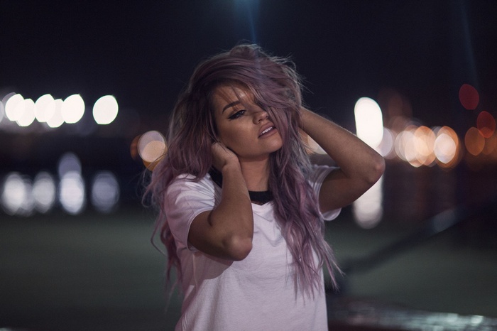 Woman with purple hair at night with bokeh lights