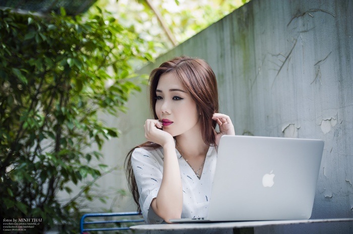 Asian woman with MacBook outdoors