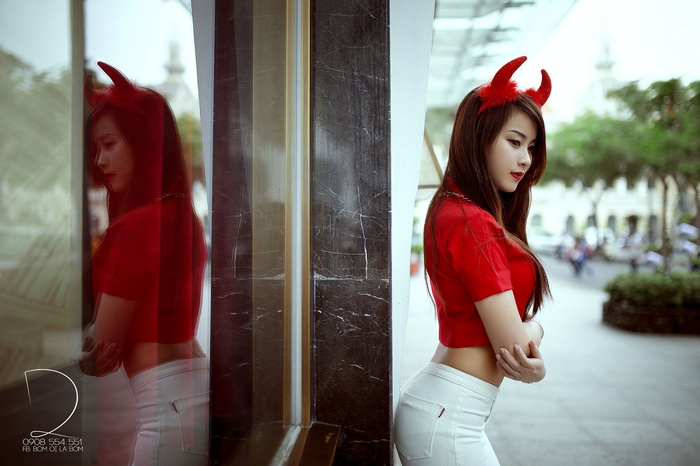 Asian woman in red crop top and white pants