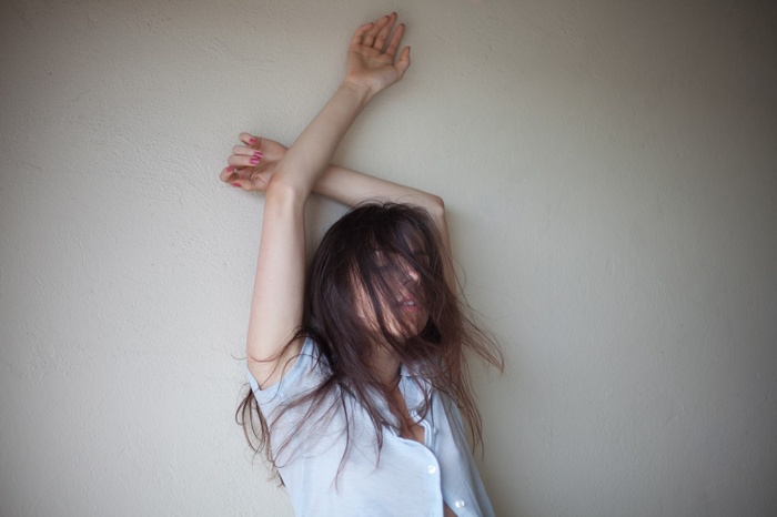 Ruby James with hair in face and arms up