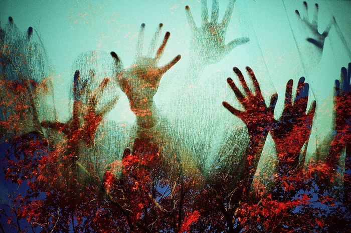 Multiple hands superimposed over autumn leaves