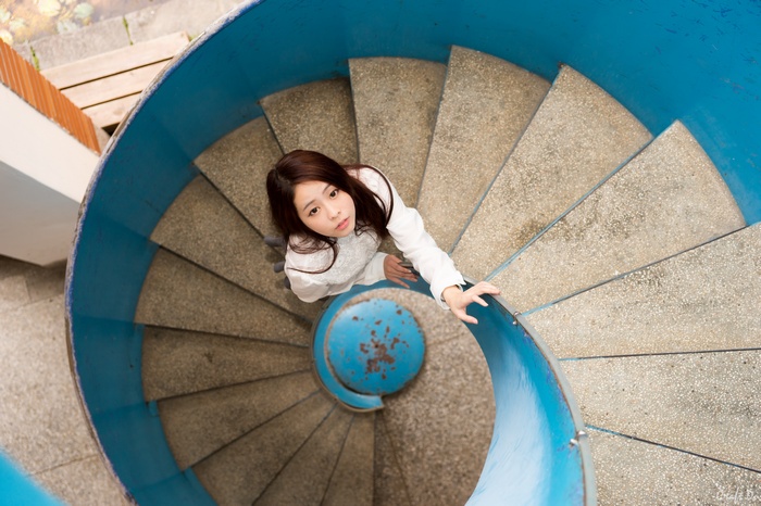 Asian woman on a blue spiral staircase