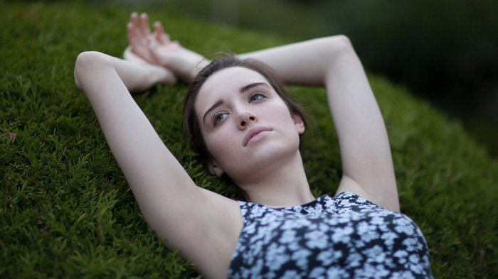 Ruby James lying on grass with arms up