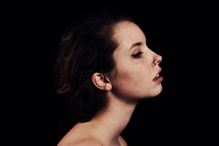 Profile of a woman with freckles and nose ring