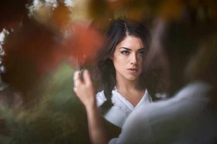 Ruby James looking into a mirror with autumn leaves