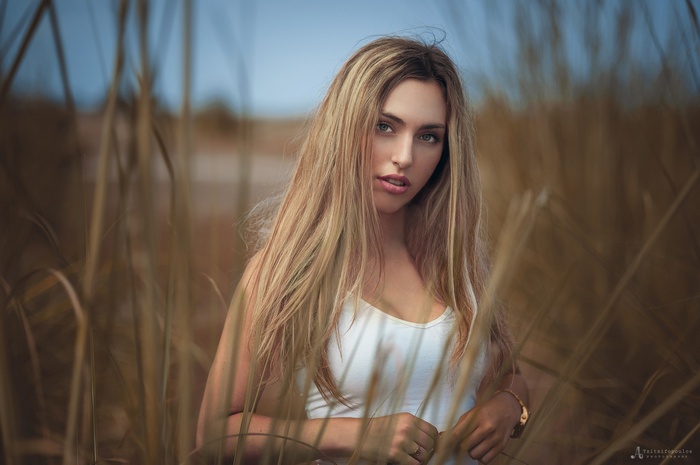 Woman with long blonde hair in tall grass