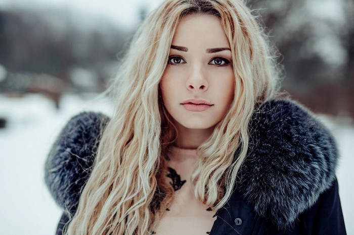 Woman with blonde hair in a fur-lined coat