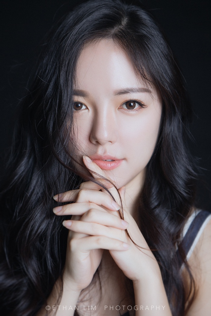 Asian woman with dark hair posing for a portrait