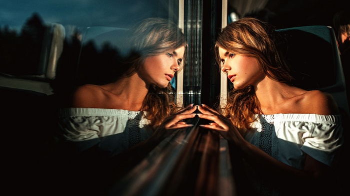 Woman looking out a window with reflection